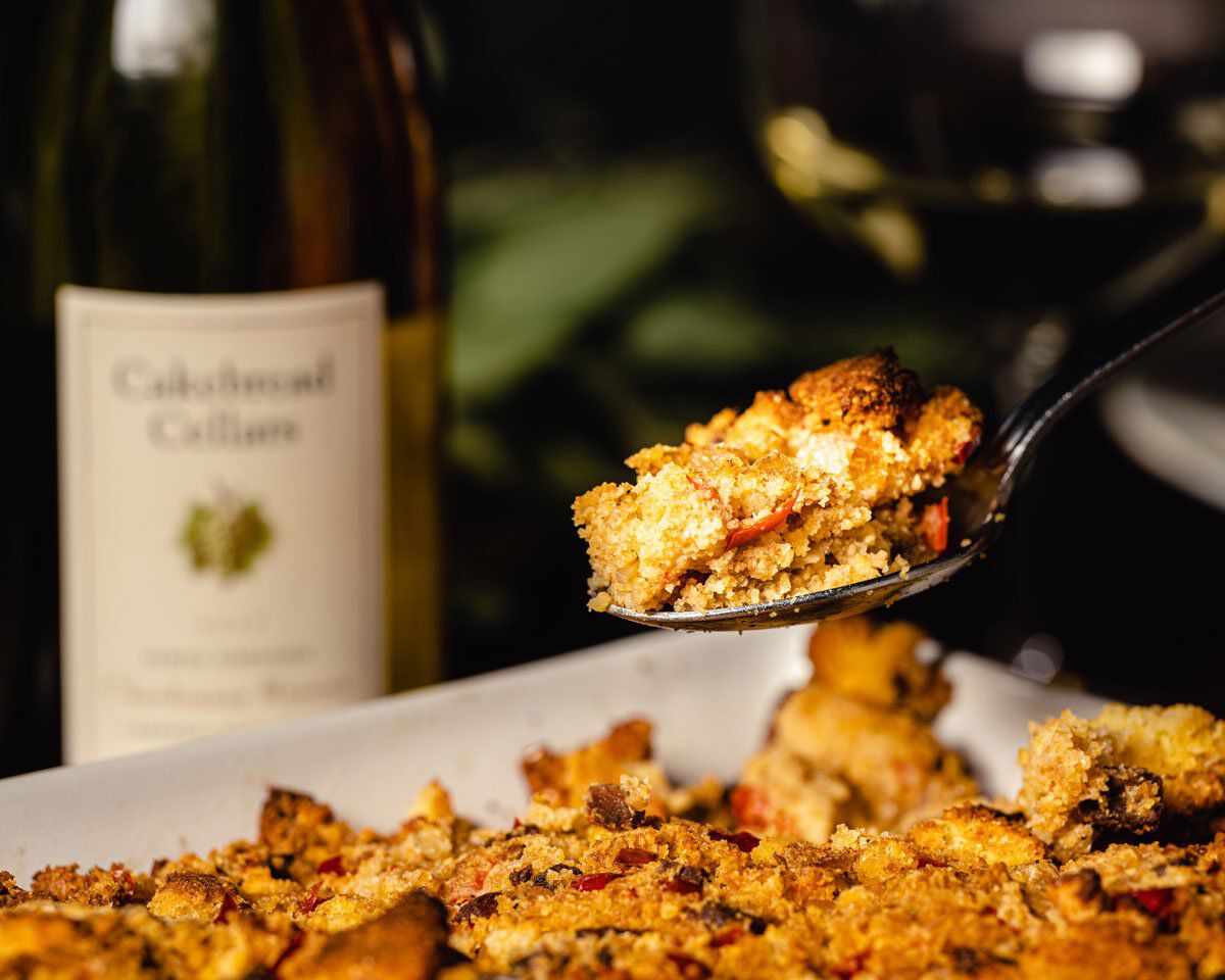 Roasted cornbread stuffing with Andouille sausage, fennel, and sweet peppers in a baking dish.