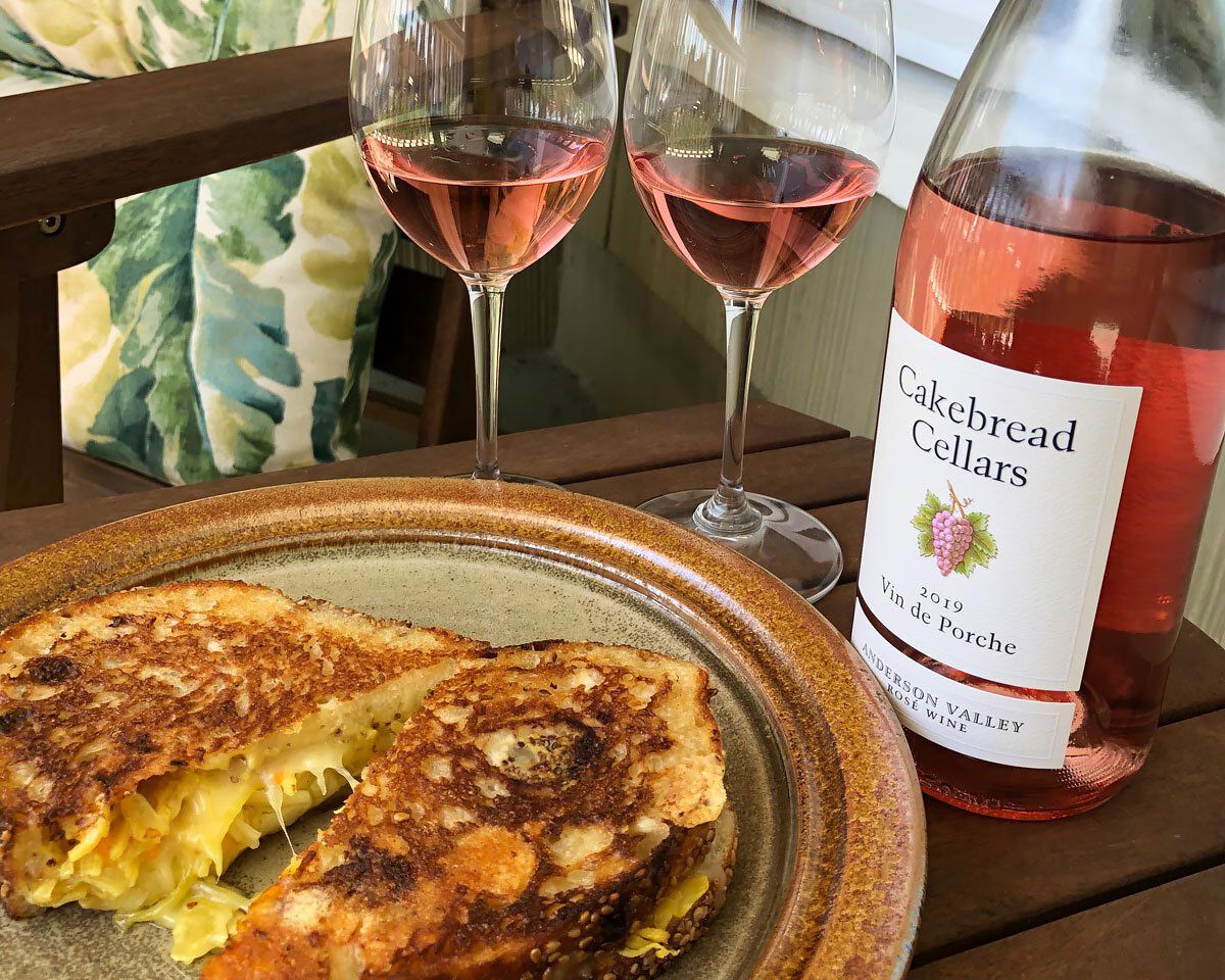 Grilled cheese sandwich with Pt. Reyes Toma, pickled golden beet slaw, and whole grain mustard, served with rosé wine and Cak.