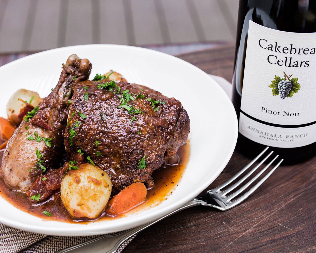 Juicy Mediterranean spiced chicken served with vegetables and herbs, paired with Cakebread Cellars Pinot Noir wine.