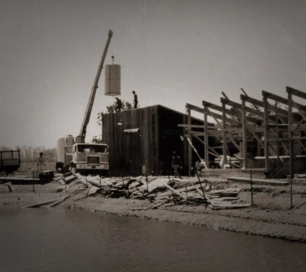 Construction of a building at Cakebread Cellars winery, with a crane and workers assembling the structure, during the day.